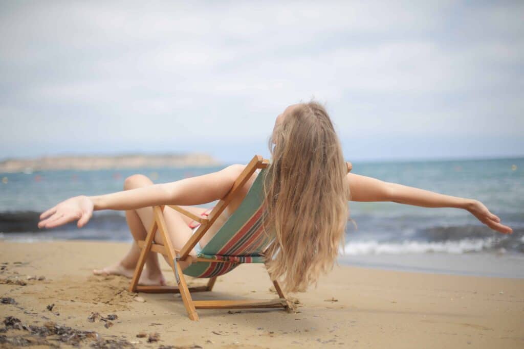 pexels-andrea-piacquadio-fille qui bronze sur un transat au bord d'un lac - où bronzer en belgique autre qu'a la plage