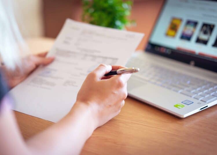 pexels-alexandr-podvalny - femme regardant facture - 5 astuces pour diminuer ta facture energie