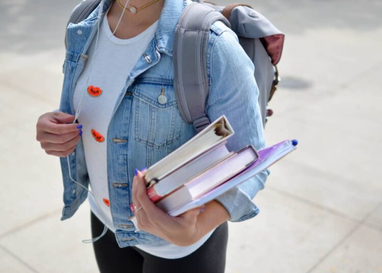 Jeune femme porte livre comment gérer le stress des études