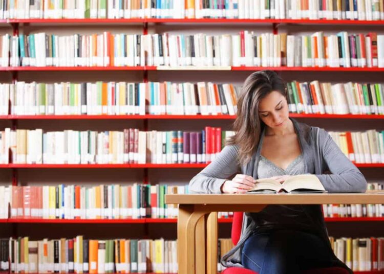 jeune femme étudier à la bibliothèque