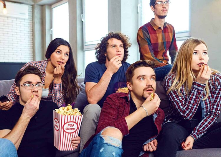 groupes de jeunes devant série et popcorn série netflix à voir
