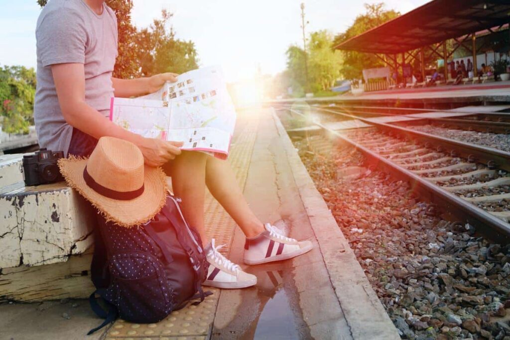jeune qui voyage avec un carte gare dossier slow travel