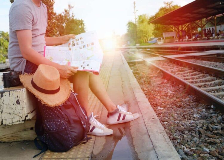 jeune qui voyage avec un carte gare dossier slow travel