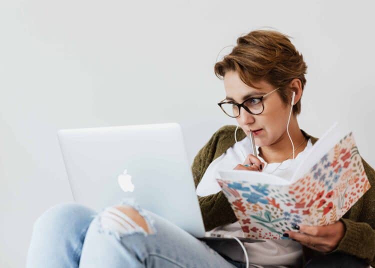 fille devant ordinateur et cahier organisation job et examens est ce possible