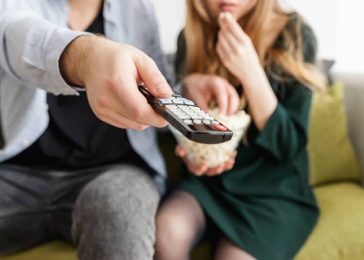 pexels-JESHOOTS.com-etudiants qui allument la tv et mangent popcorn Les films d'horreur attendus en 2021 (si tout va bien)