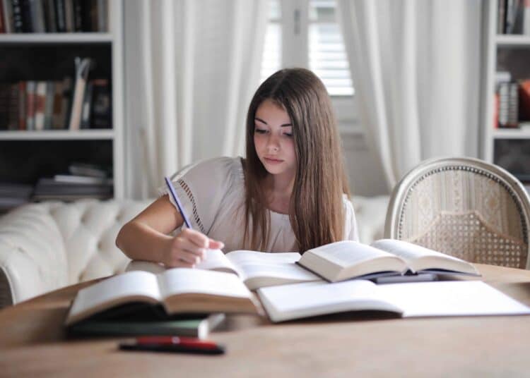 Pexels Andrea Piacquadio - Jeune femme écrit quelque chose - 10 conseils pour lutter contre la procrastination