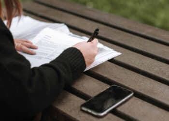 Pexels Anete Lusina - Jeune femme écrit quelque chose - Les différents types de contrats de travail en Belgique