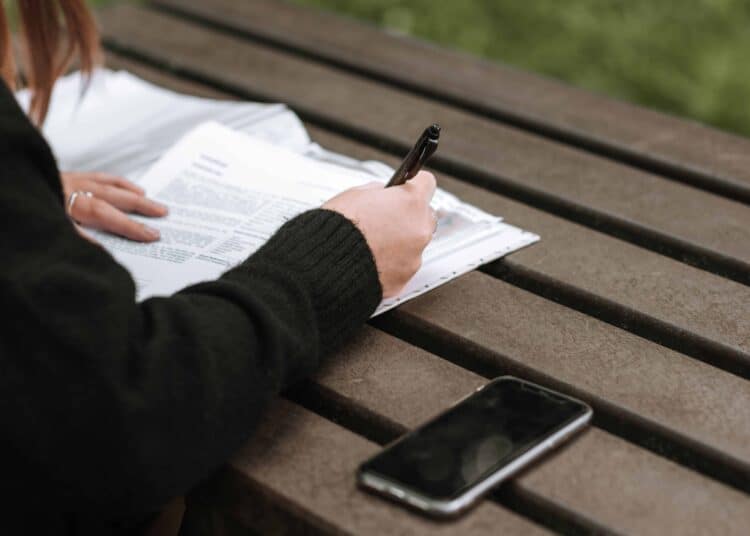 Pexels Anete Lusina - Jeune femme écrit quelque chose - Les différents types de contrats de travail en Belgique