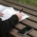 Pexels Anete Lusina - Jeune femme écrit quelque chose - Les différents types de contrats de travail en Belgique