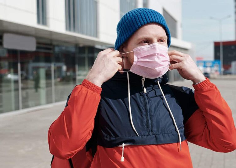 Pexels Norma Mortenson - Jeune qui met son masque - Avantages porter le masque