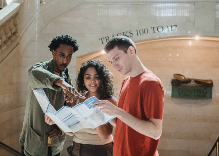 pexels-william-fortunato-trois etudiants qui regardent sur une carte Comment préparer un voyage pour ses vacances étudiantes