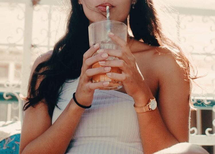 Unsplash Zino De Groot - Jeune femme boit un cocktail - Les effets indésirables des boissons énergisantes