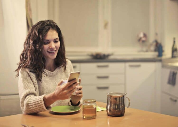 pexels-andrea-piacquadio - jeune femme rigole sur son telephone - 6 memes qui resument bien ton mois de mars d'etudiant