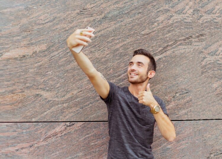 pexels-oleg-magni-etudiant qui se prend en selfie pouce en l'air - Les 6 choses qui se passent dans les films et séries et qu’on aimerait dans la vraie vie