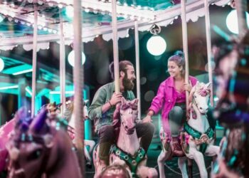 @unsplash - sept commercial - un homme et une femme sur le manege des chevaux qui se sourient - femme qui touche sa main - Je suis amoureux.se de mon/ma meilleur.e ami.e, que faire ?