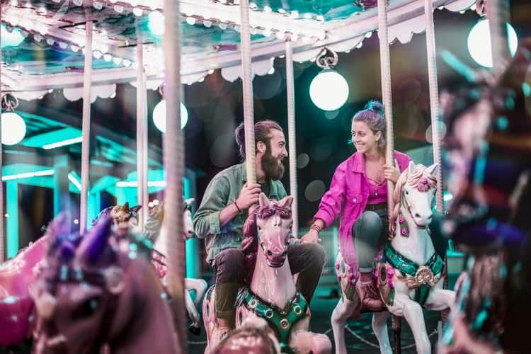 @unsplash - sept commercial - un homme et une femme sur le manege des chevaux qui se sourient - femme qui touche sa main - Je suis amoureux.se de mon/ma meilleur.e ami.e, que faire ?