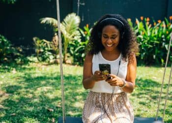 pexels-anna-tarazevich-etudiante qui écoute de la musique dehors - Top 5 des musiques à mettre dans sa playlist pour l'été