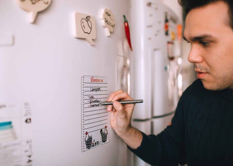 pexels-helena-lopes-etudiant qui écrit sur son frigo - 7 magnets pour ton frigo