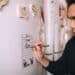 pexels-helena-lopes-etudiant qui écrit sur son frigo - 7 magnets pour ton frigo