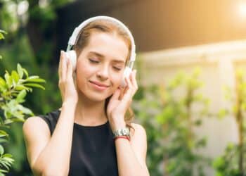 pexels-tirachard-kumtanom-femme qui écoute de la musique dehors _ Les bienfaits de la musique sur notre vie étudiante
