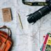 unsplash - Annie Spratt - appareil photo sac à dos bloc notes et livrets sur une grande carte - top 5 des city trips à faire absolument