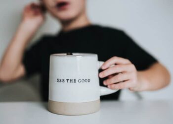 unsplash - Nathan Dumlao - enfant qui tient une tasse où il est écrit see the good dans sa main - et si on optait pour le positif ?