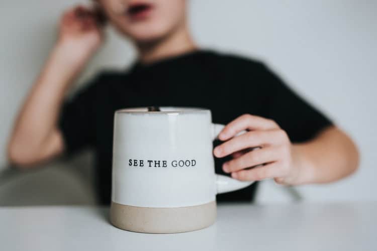 unsplash - Nathan Dumlao - enfant qui tient une tasse où il est écrit see the good dans sa main - et si on optait pour le positif ?