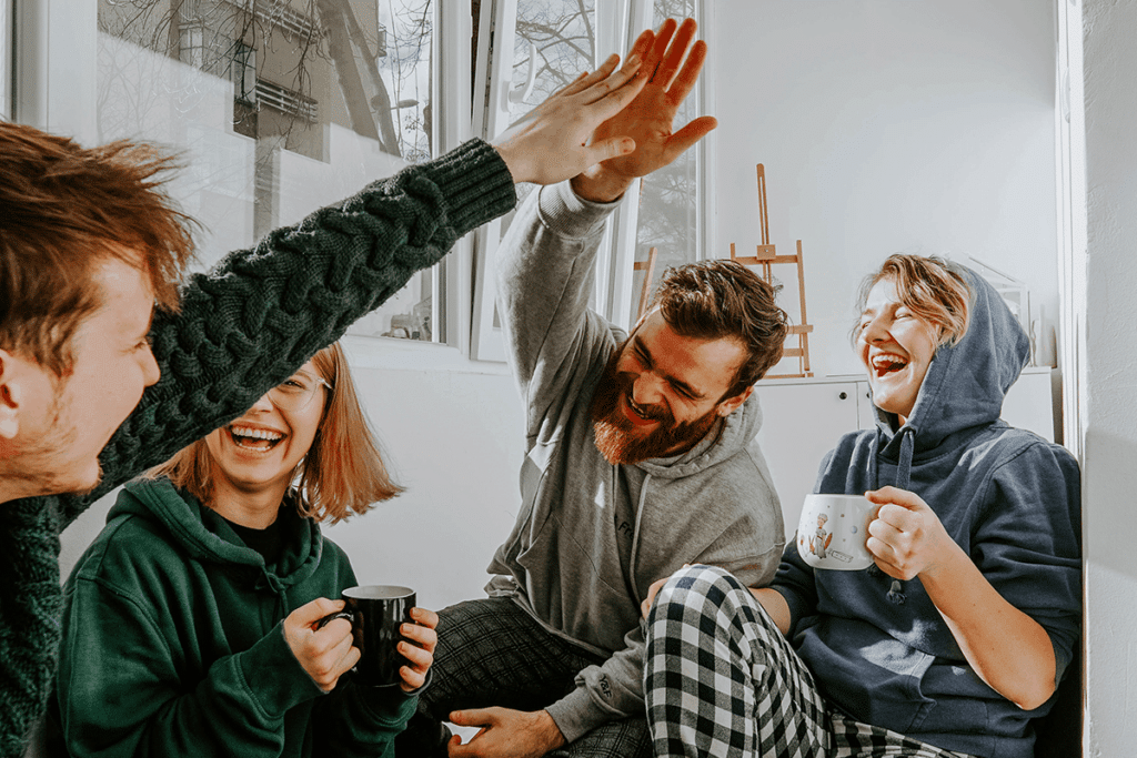 unsplash - toa-heftiba - 4 potes qui rigolent dans un kot - guide de survie de l'étudiant en coloc