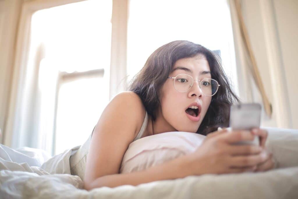 pexels-andrea-piacquadio-étudiante dans son lit sur son téléphone-Les réactions qu’on a déjà eues si on kiffe l’astro