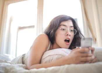 pexels-andrea-piacquadio-étudiante dans son lit sur son téléphone-Les réactions qu’on a déjà eues si on kiffe l’astro