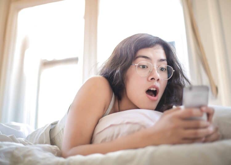 pexels-andrea-piacquadio-étudiante dans son lit sur son téléphone-Les réactions qu’on a déjà eues si on kiffe l’astro