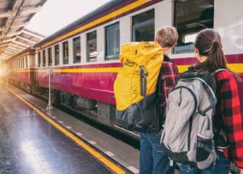 pexels-veerasak-piyawatanakul-deux jeunes devant un train - Les 6 raisons de prendre le train pour voyager