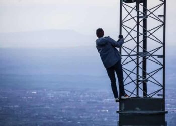 unsplash - Jack Sloop - homme suspendu à un poteau en hauteur - les phrases que l'on en a marre d'entendre quand on est grand