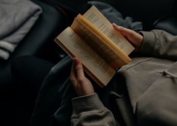 unsplash - Lilly Rum - personne qui lit un livre avec un sweat - top 5 des livres à lire pendant ta pause blocus