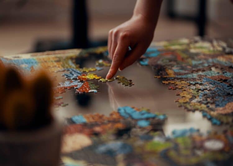 unsplash -ross-sneddon-etudiant qui fait un puzzle - 5 puzzles pour occuper ton temps libre pendant tes vacances étudiantes