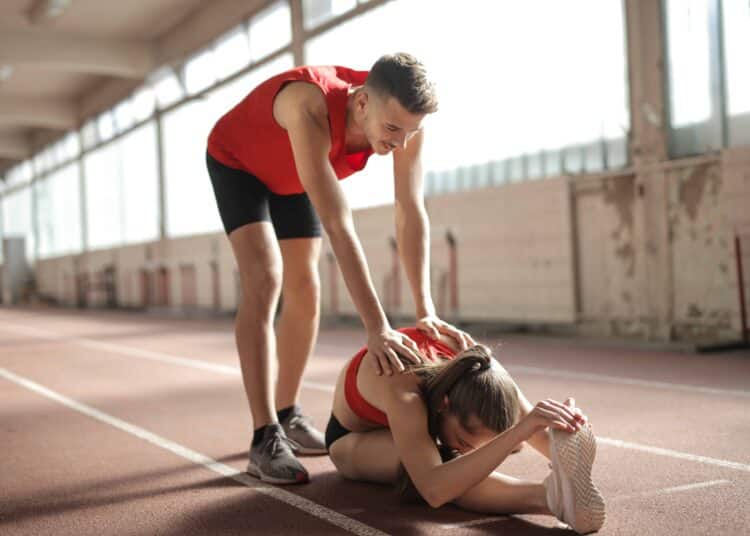 pexels-andrea-piacquadio-couple etudiant qui s'étirent - Faire du sport en couple 5 exercices à faire à deux