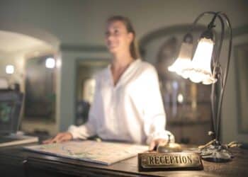 pexels-andrea-piacquadio-jeune femme devant la reception d'un hotel - Top 7 des phrases à apprendre dans la langue du pays que tu veux visiter