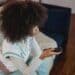pexels-andres-ayrton-fille avec une télécommande - 7 signes que tu es accro aux séries