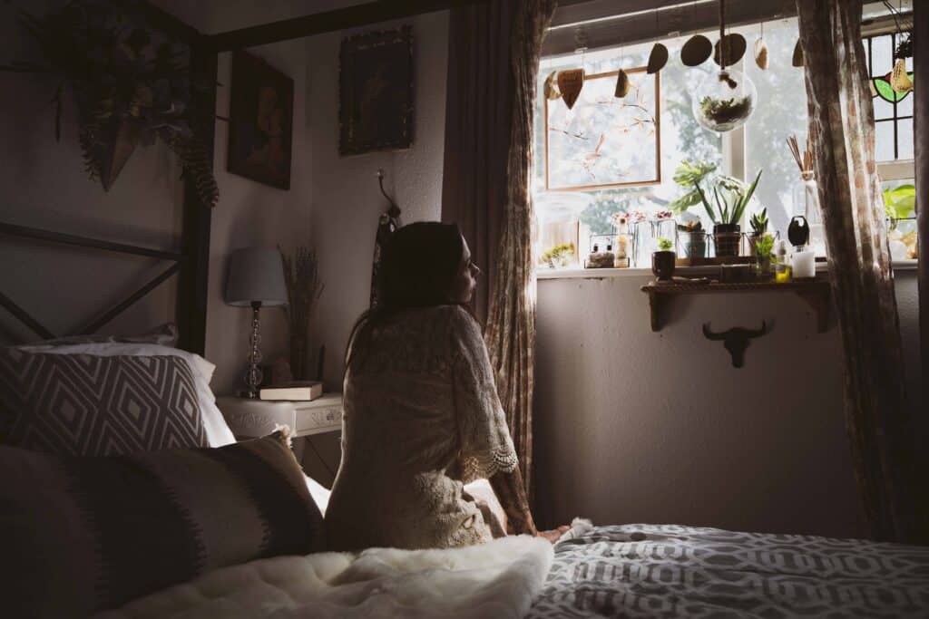 unsplash - ashley-byrd-étudiante sur son lit dans son kot - Les gadgets à avoir dans ta chambre de kot