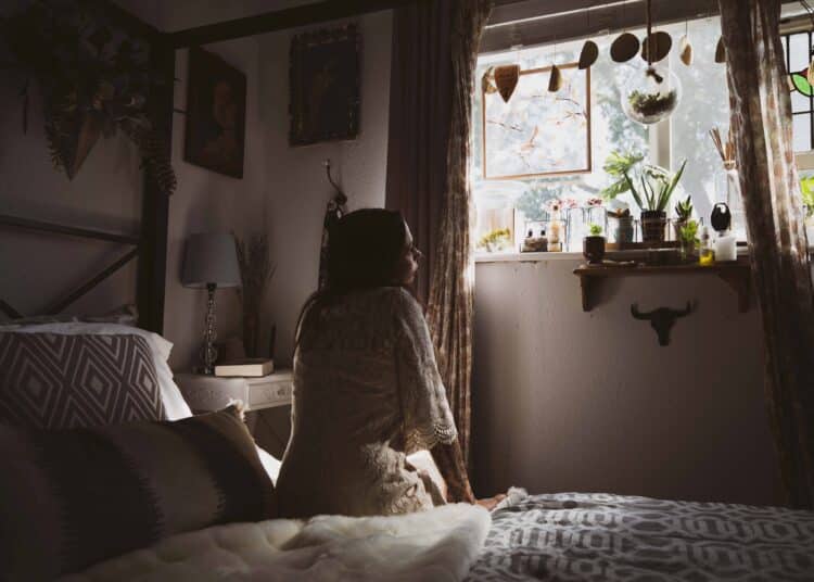 unsplash - ashley-byrd-étudiante sur son lit dans son kot - Les gadgets à avoir dans ta chambre de kot