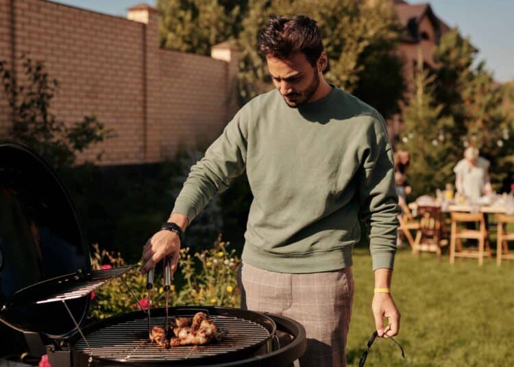 pexels-askar-abayev-jeune homme qui s'occupe du barbecue - comment organiser un barbecue sans stress