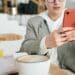 pexels-shvets-production-fille sur son telephone qui prend un cafe - 7 choses à faire pour se détendre entre deux cours