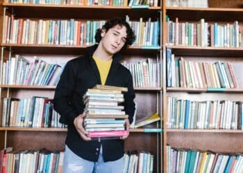 pexels-rodnae-productions- garcon etudiant qui est dans une bibliothèque avec des livres - 6 astuces pour réussir ses cours de langues