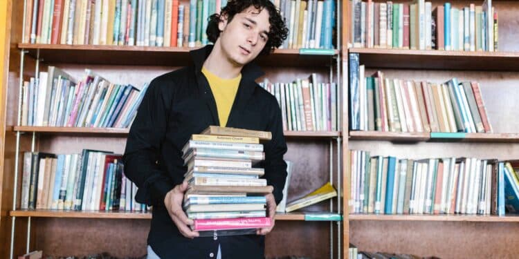 pexels-rodnae-productions- garcon etudiant qui est dans une bibliothèque avec des livres - 6 astuces pour réussir ses cours de langues