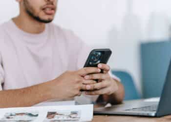 pexels-michael-burrows-jeune homme sur telephone devant ordinateur Comment réussir sa lettre de motivation