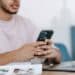 pexels-michael-burrows-jeune homme sur telephone devant ordinateur Comment réussir sa lettre de motivation