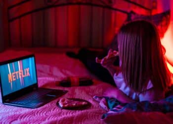 pexels-vaner-fille qui regarde une serie avec une pizza - Commencer une série en plein blocus, est-ce vraiment le bon plan
