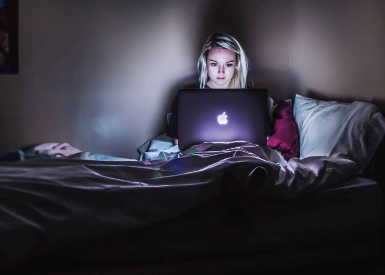 unsplash Victoria Heath fille devant l'ordinateur sur le lit Les 5 habitudes des étudiants qui sont mauvaises pour la santé
