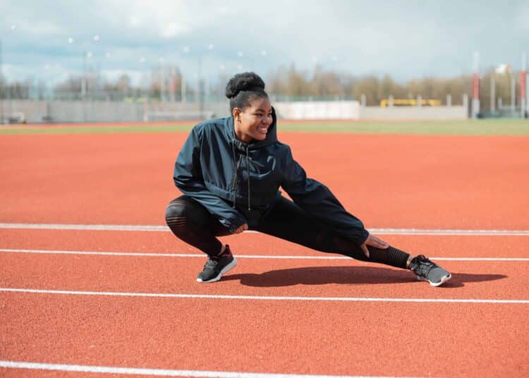 pexels-mikhail-nilov-fille qui s'étire sur un terrain d'athlétisme - Comment trouver le sport qui me convient durant mes études