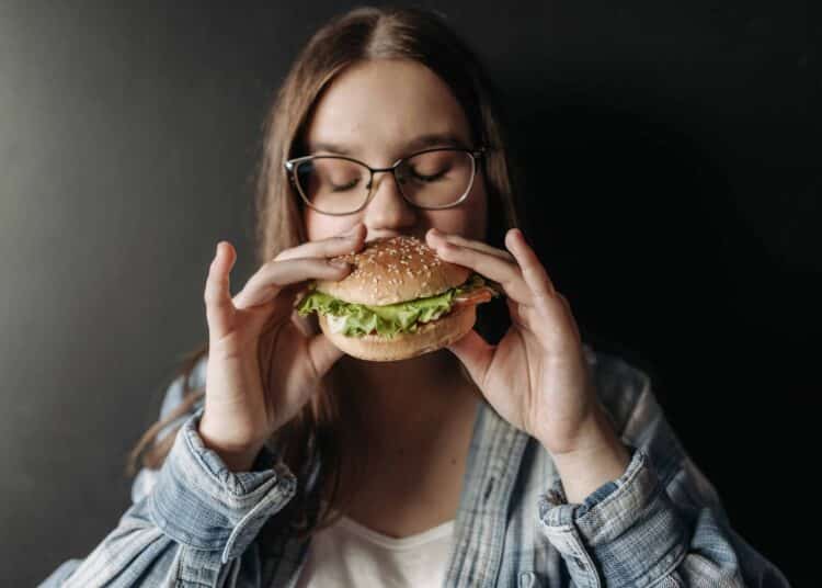 pexels-pavel-danilyuk fille qui mange un hamburger 4 signes que tu es accro à la malbouffe